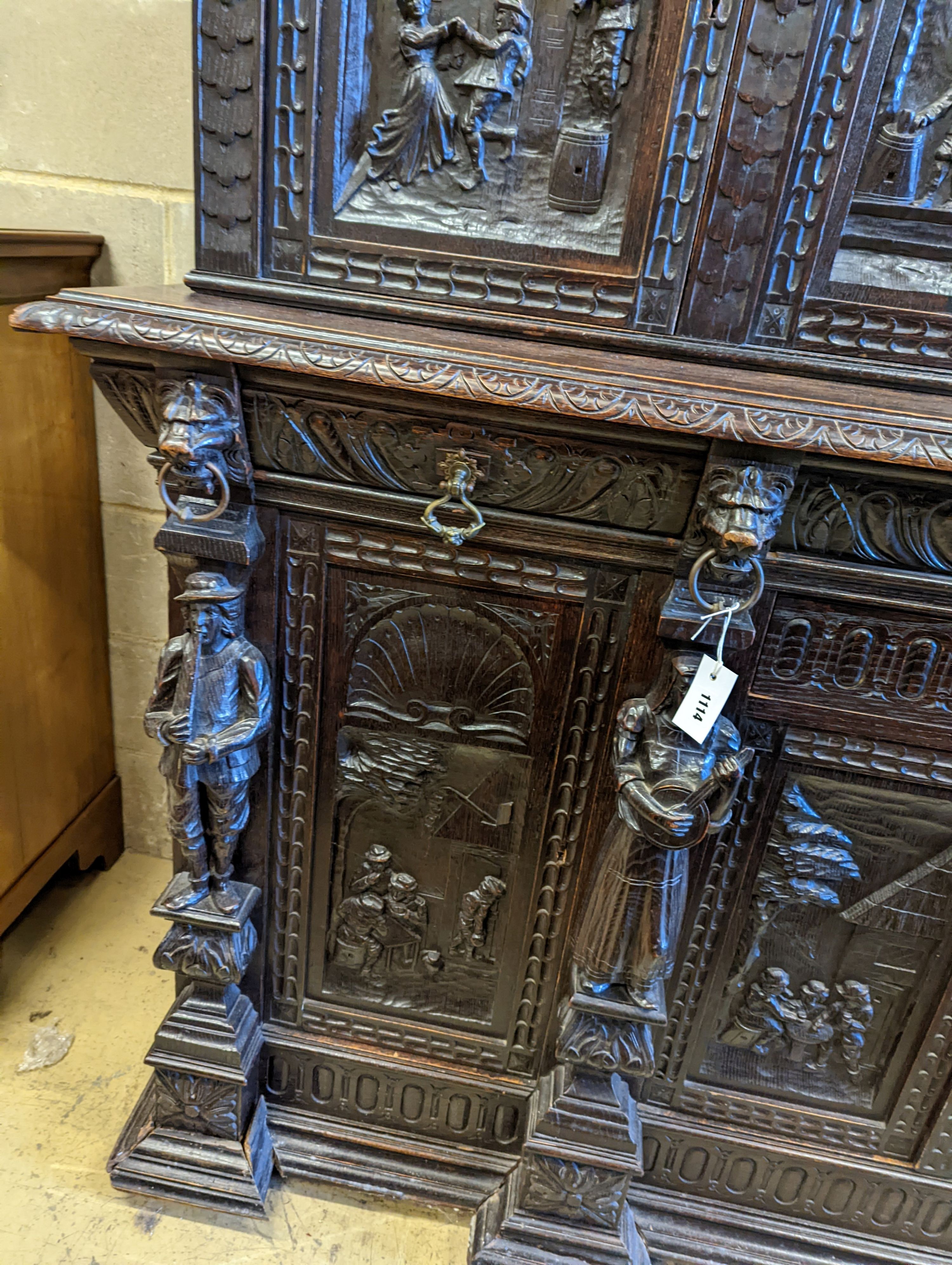 An early 20th century carved oak court cupboard in the Flemish style, length 200cm, depth 58cm, height 212cm